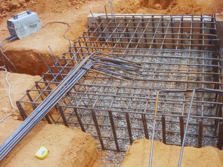 Fundações de concreto armado com armação metálica em obra, destacando o trabalho da Potência Estrutural em garantir estabilidade e segurança para edificações comerciais e industriais.